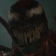 The oozing blood-red symbiote Carnage grins his overly fanged mouth.